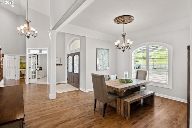 dining area with baseboards, an inviting chandelier, and wood finished floors