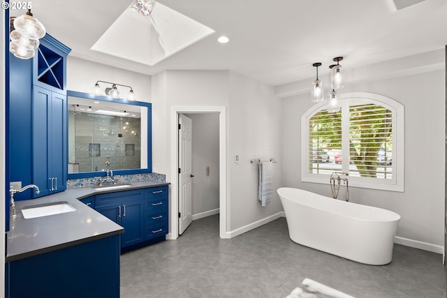 bathroom with double vanity, a sink, a soaking tub, and a stall shower