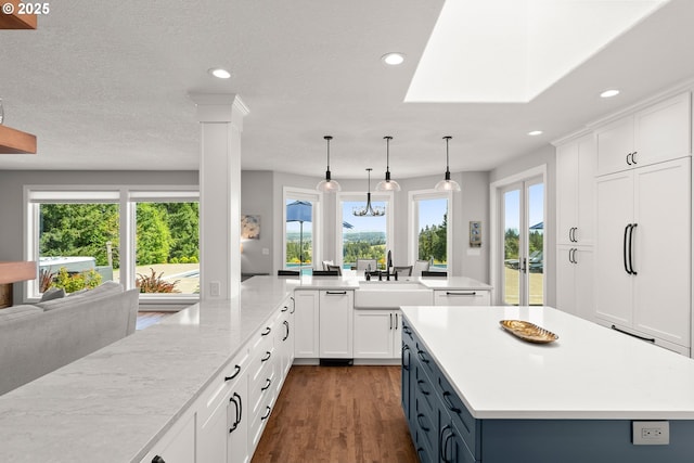 kitchen featuring recessed lighting, a spacious island, a sink, and dark wood finished floors