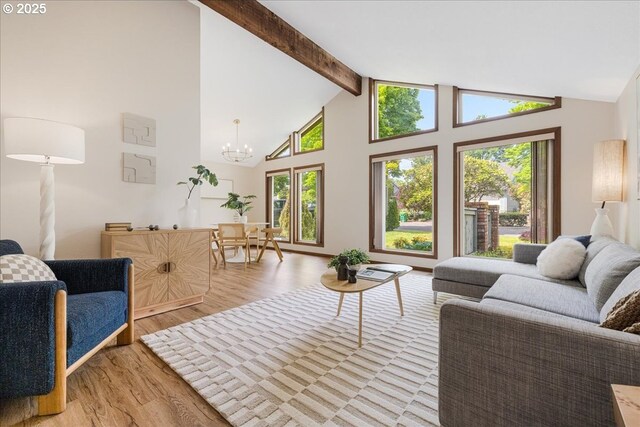 living room with light wood-type flooring, beamed ceiling, a chandelier, and high vaulted ceiling