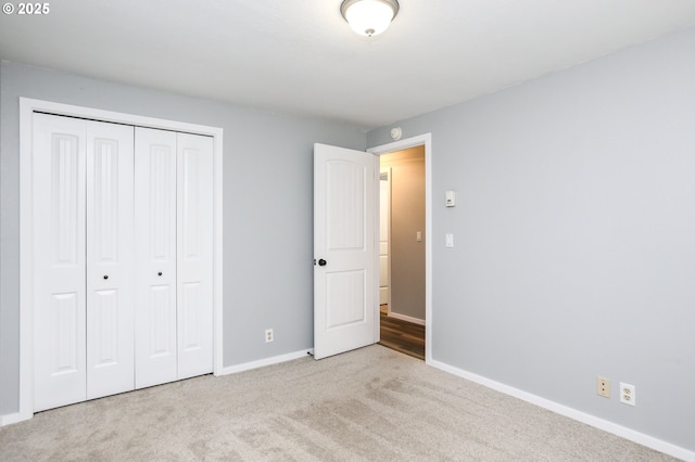 unfurnished bedroom featuring light carpet and a closet