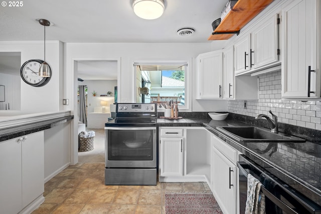 kitchen featuring dark countertops, black dishwasher, white cabinetry, a sink, and stainless steel range with electric cooktop