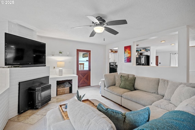 living room featuring a ceiling fan and a textured ceiling