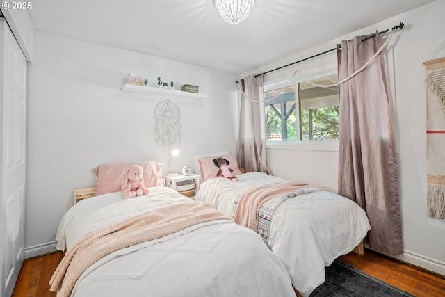 bedroom with wood finished floors and a closet