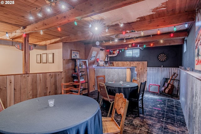 dining area featuring beamed ceiling, wooden walls, tile patterned floors, wooden ceiling, and a dry bar