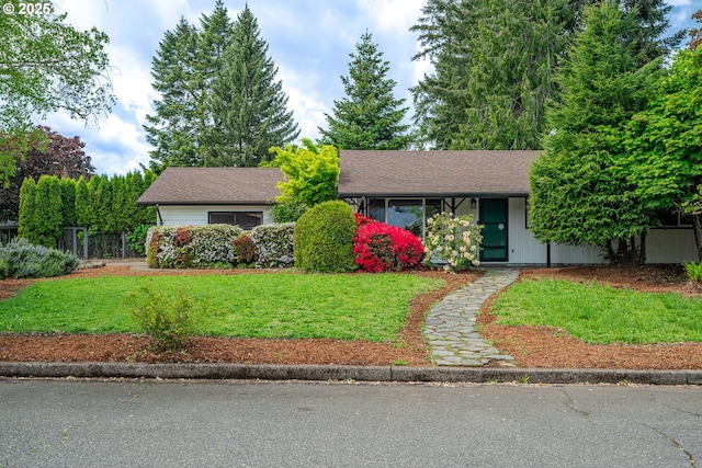 view of front of property featuring a front lawn, roof with shingles, and fence