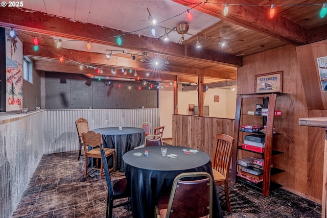 dining room featuring wooden walls, wood ceiling, and beam ceiling