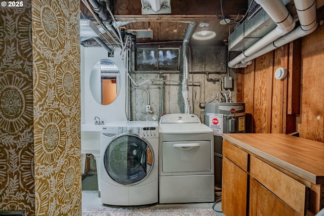 laundry room featuring strapped water heater and washing machine and clothes dryer