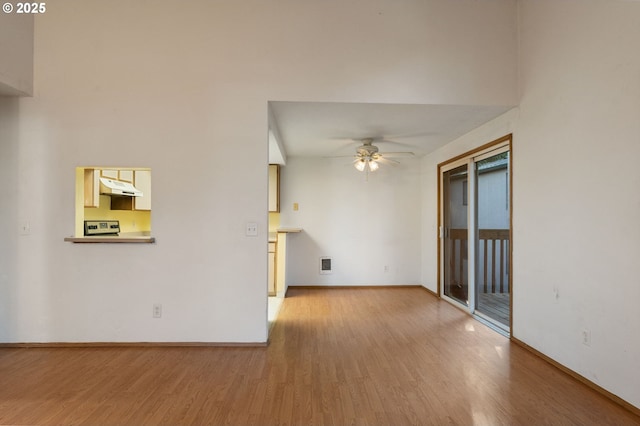 empty room with ceiling fan and light hardwood / wood-style flooring