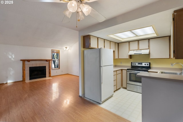 kitchen with stainless steel electric range oven, lofted ceiling, sink, white fridge, and ceiling fan