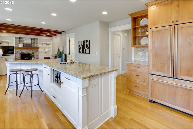 kitchen with open shelves, recessed lighting, light wood-style flooring, and open floor plan