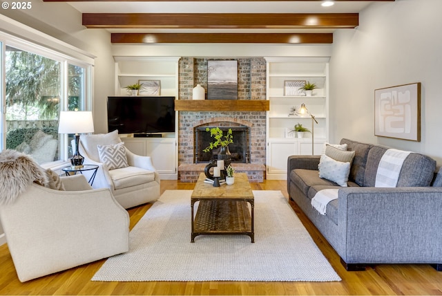 living room featuring beamed ceiling, wood finished floors, and a fireplace