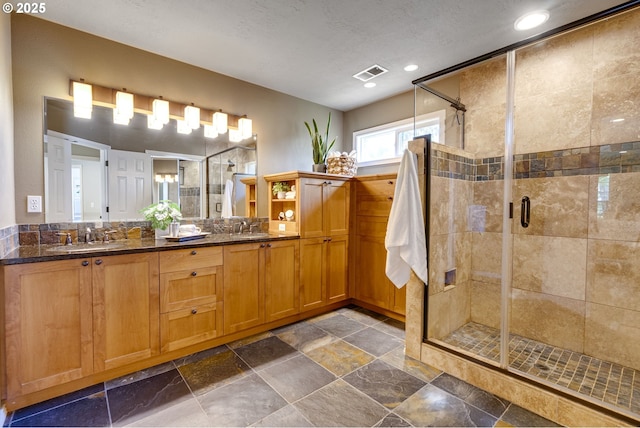 bathroom with visible vents, a sink, a stall shower, and recessed lighting