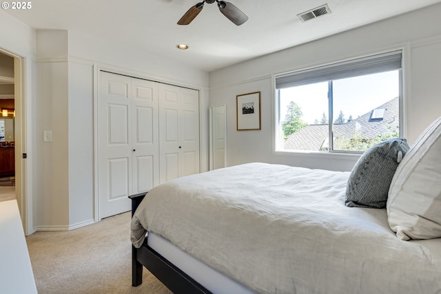 bedroom featuring ceiling fan, light colored carpet, baseboards, visible vents, and a closet