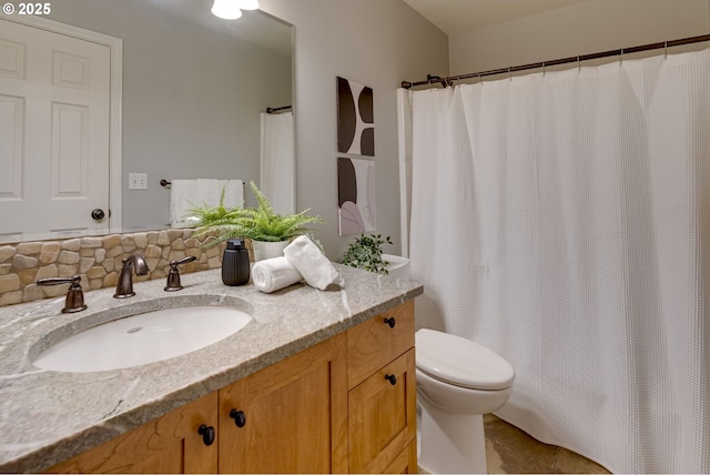 bathroom featuring toilet, a shower with shower curtain, and vanity