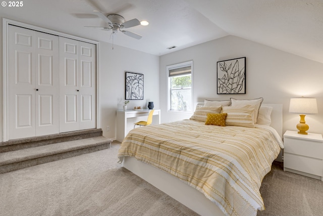 carpeted bedroom featuring ceiling fan, visible vents, vaulted ceiling, and a closet