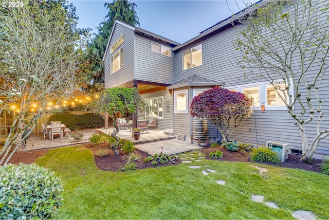 rear view of property featuring a lawn, fence, and a patio area
