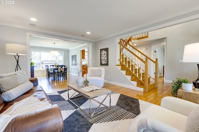 living area featuring ornamental molding, stairs, and light wood finished floors