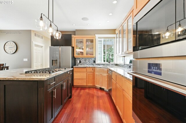 20817 NE 101st Ct, Battle Ground, WA 98604 - kitchen featuring stainless steel appliances, glass insert cabinets, tasteful backsplash, dark wood-style flooring, and light stone counters