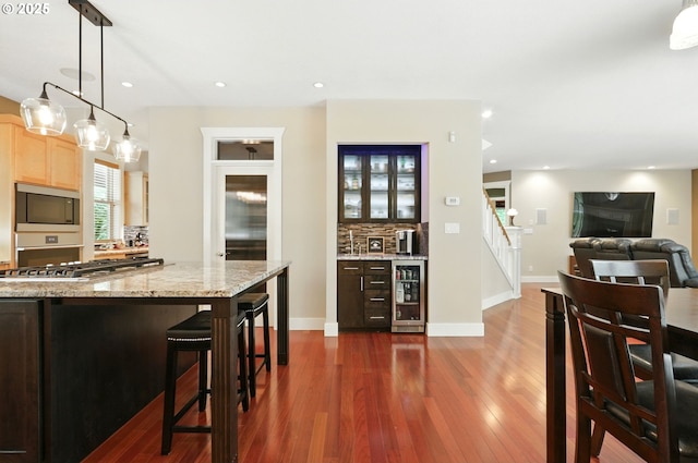 20817 NE 101st Ct, Battle Ground, WA 98604 - kitchen with beverage cooler, stainless steel appliances, dark wood-style flooring, light brown cabinets, and a kitchen bar