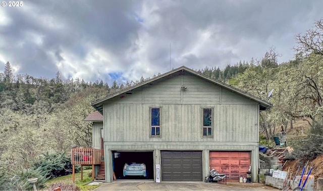 view of side of home featuring a garage and a deck