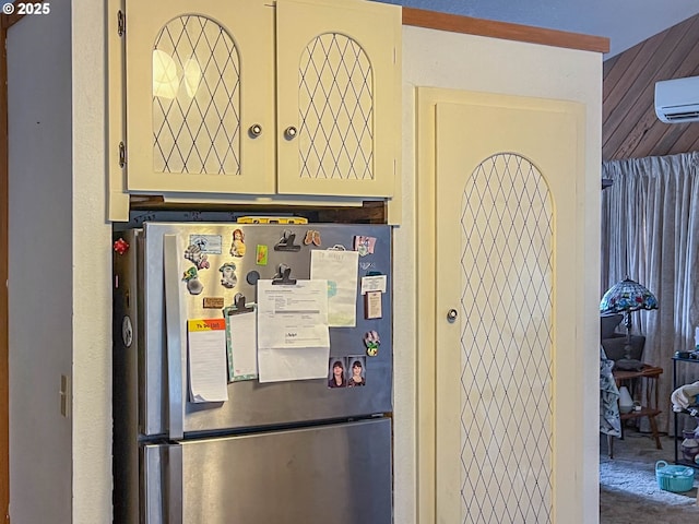 kitchen with wooden walls, stainless steel fridge, carpet floors, and an AC wall unit