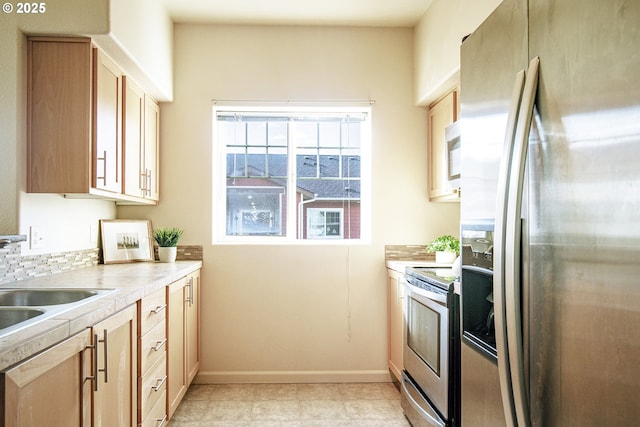 kitchen featuring appliances with stainless steel finishes, sink, and light brown cabinetry