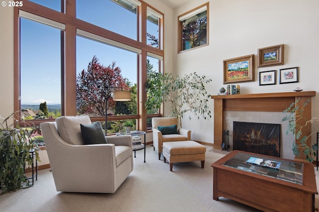 17514 Brookhurst Dr, Lake Oswego, OR 97034 - carpeted living room featuring healthy amount of natural light, a tiled fireplace, a high ceiling, and baseboards