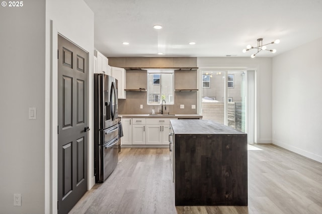 5958 SE 16th Loop, Gresham, OR 97080 - kitchen with stainless steel fridge, open shelves, a sink, backsplash, and light wood-style floors