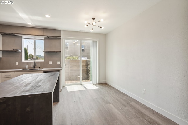5958 SE 16th Loop, Gresham, OR 97080 - kitchen featuring a sink, open shelves, baseboards, light wood-style floors, and a chandelier