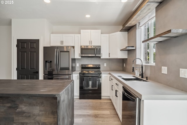 5958 SE 16th Loop, Gresham, OR 97080 - kitchen featuring stainless steel appliances, a sink, white cabinets, light wood finished floors, and recessed lighting