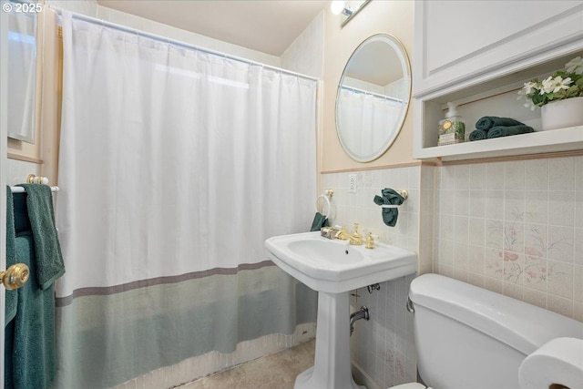 bathroom with a shower with curtain, toilet, and tile walls