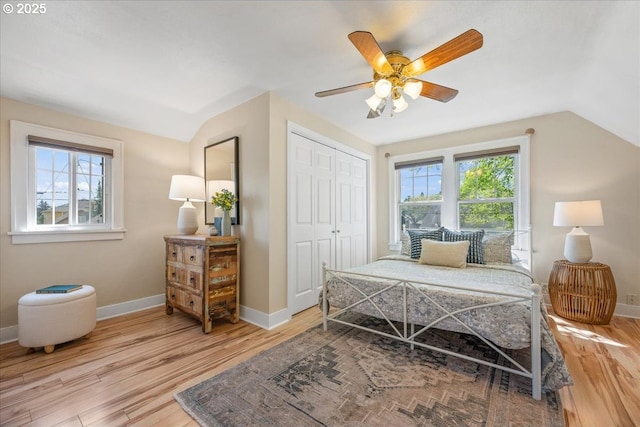 bedroom featuring baseboards, lofted ceiling, and wood finished floors