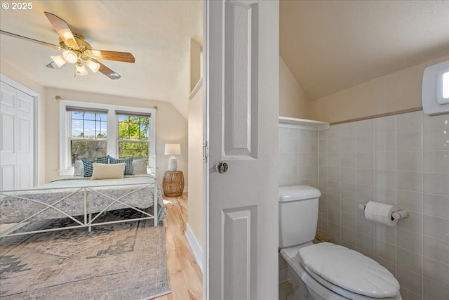 bathroom with wood finished floors, ceiling fan, lofted ceiling, and toilet