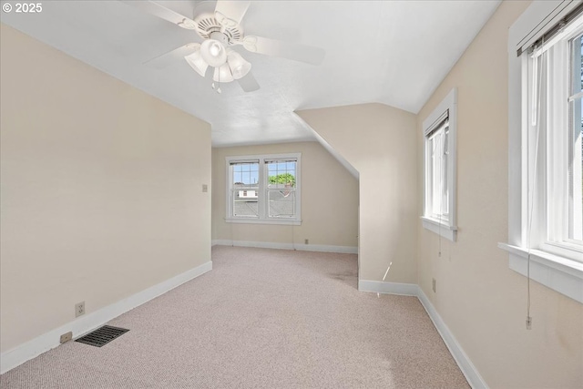 bonus room with light carpet, a ceiling fan, baseboards, vaulted ceiling, and visible vents