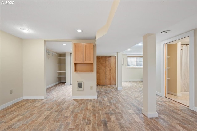 unfurnished living room with recessed lighting, baseboards, and light wood-style floors