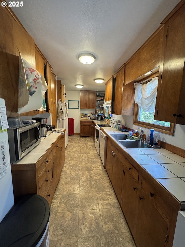 318 W 20th St, The Dalles, OR 97058 - kitchen featuring tile countertops, white appliances, brown cabinetry, and a sink