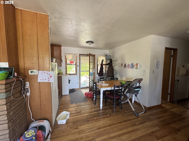 318 W 20th St, The Dalles, OR 97058 - dining room with wood finished floors, a textured ceiling, and baseboards