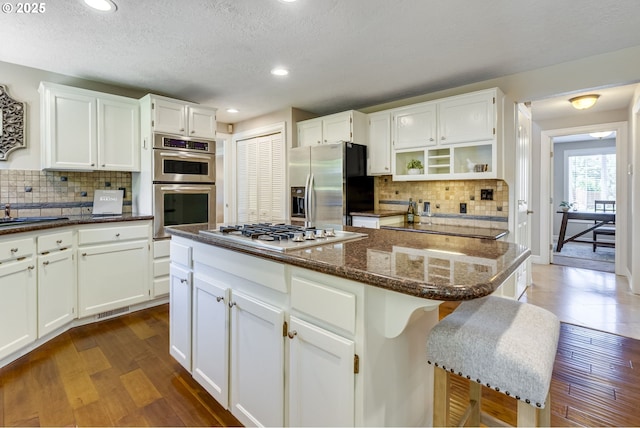 17865 NW Elk Meadow Ln, Portland, OR 97229 - kitchen with stainless steel appliances, tasteful backsplash, dark wood-style floors, recessed lighting, and a textured ceiling