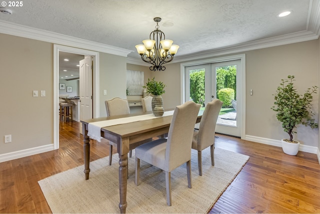 17865 NW Elk Meadow Ln, Portland, OR 97229 - dining space featuring a chandelier, a textured ceiling, ornamental molding, baseboards, and french doors