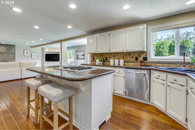17865 NW Elk Meadow Ln, Portland, OR 97229 - kitchen featuring stainless steel appliances, recessed lighting, plenty of natural light, white cabinets, and a textured ceiling