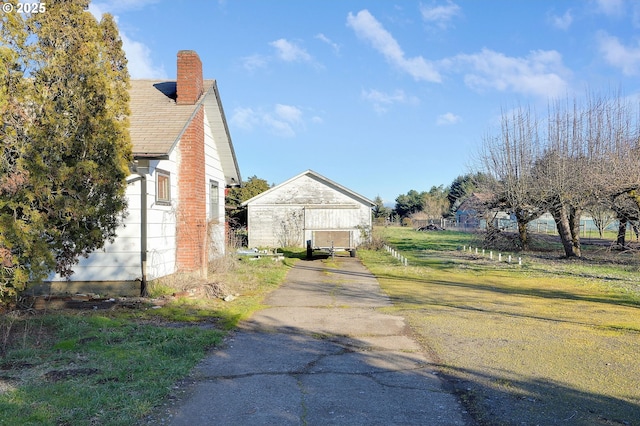 view of home's exterior featuring an outbuilding and a chimney