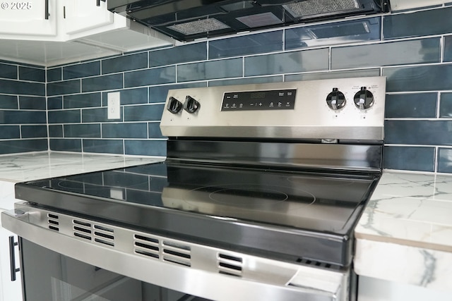 interior details featuring light stone countertops, backsplash, white cabinets, and stainless steel range with electric cooktop