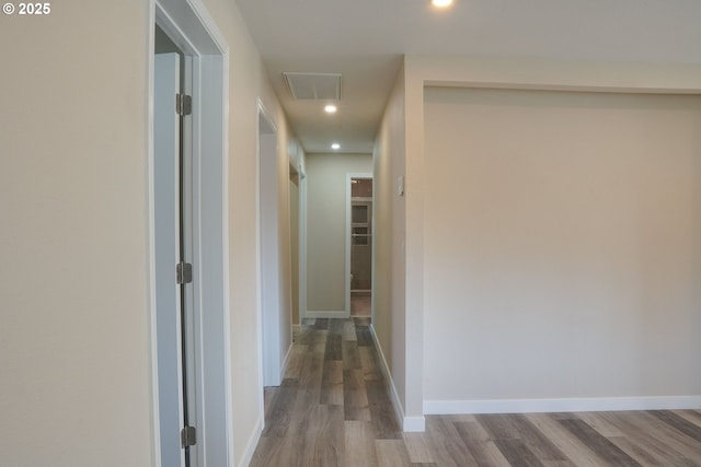 hall with visible vents, recessed lighting, baseboards, and wood finished floors