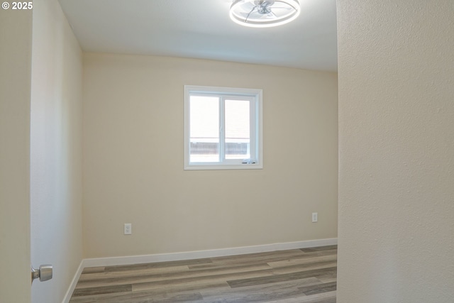 spare room featuring wood finished floors and baseboards