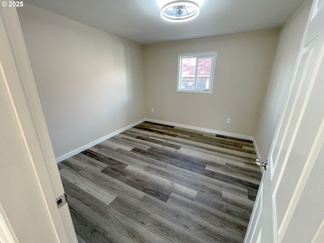 empty room featuring baseboards and wood finished floors