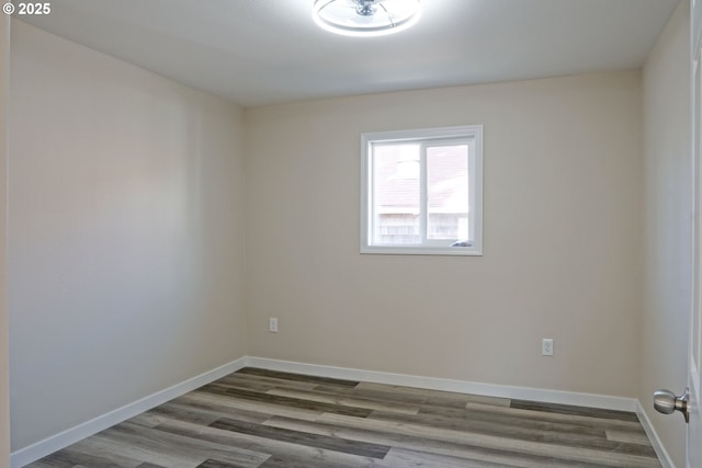 unfurnished room with baseboards and wood finished floors