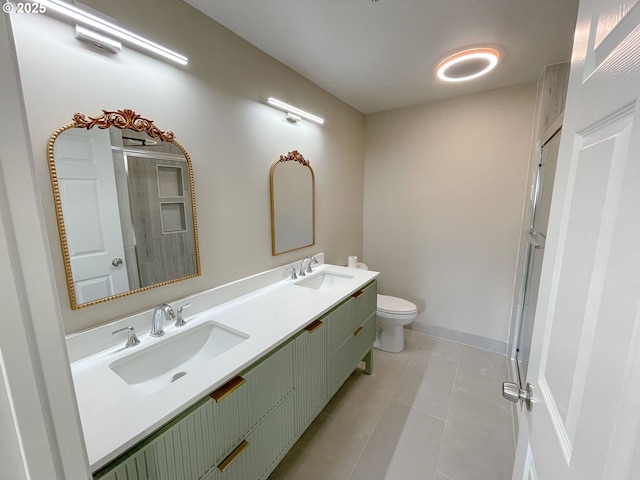 bathroom with double vanity, tile patterned floors, toilet, and a sink