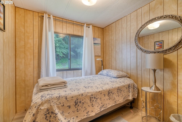 bedroom featuring wooden walls and wood finished floors