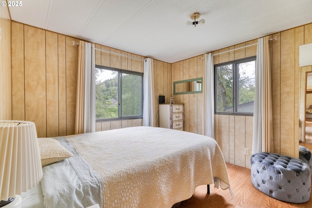 bedroom with wooden walls and wood finished floors